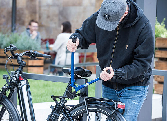 Fahrraddiebstahl mit einem Bolzenschneider Eine Person versucht, mit einem Bolzenschneider das Schloss eines Fahrrads zu knacken.